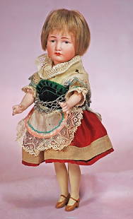 PETITE GERMAN BISQUE CHARACTER, GRETCHEN, 114, BY KAMMER AND REINHARDT: PETITE GERMAN BISQUE CHARACTER, GRETCHEN, 114, BY KAMMER AND REINHARDT. 7 ½”. Marks: K *R 114. Bisque socket head, painted features, blue eyes, tapered brows, closed mouth, original