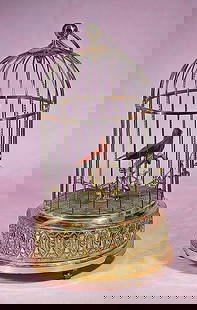 DELIGHTFUL AUTOMATON OF SINGING BIRD IN GILDED CAGE: DELIGHTFUL AUTOMATON OF SINGING BIRD IN GILDED CAGE. 11 ½”. A beautifully detailed bird cage with sculpted detail and gold finish on the base, and gilded brass cage rods; brass ball finial