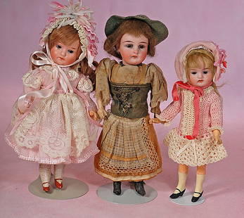 THREE SMALL GERMAN BISQUE DOLLS: THREE SMALL GERMAN BISQUE DOLLS. 7” to 8 ½”. Each is bisque socket with stationary glass eyes, open mouth, upper teeth, mohair or human hair wig, five-piece jointed paper