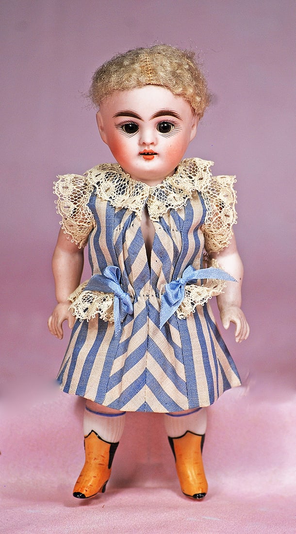 GERMAN ALL-BISQUE DOLL WITH YELLOW BOOTS BY KESTNER: GERMAN ALL-BISQUE DOLL WITH YELLOW BOOTS BY KESTNER. 6 ½”. Marks: 184. All-bisque, jointed at shoulders and hips, brown sleep eyes, painted lashes, feathered brows, upper teeth, original bl
