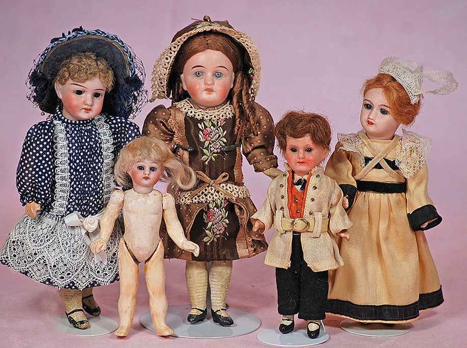 FIVE MINIATURE BISQUE DOLLS: FIVE MINIATURE BISQUE DOLLS. 5” to 7”. Each is socket head with glass eyes, five piece jointed paper mache/composition body. Four are bisque head with open mouth, one painted bisque with c