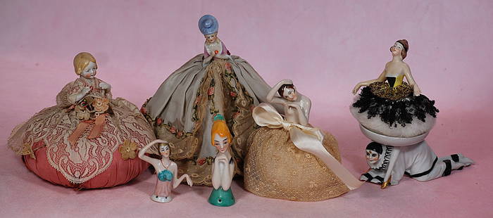 COLLECTION OF HALF DOLLS AND PIN CUSHION DOLLS: COLLECTION OF HALF DOLLS AND PIN CUSHION DOLLS. 5&#8221; porcelain half child with lace covered pincushion base; 4 &#189;&#8221; porcelain doll with brown hair and one arm posed over her head, on lace