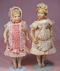 TWO BISQUE DOLLS WITH SCULPTED ORANTE BONNET BY ARTIST KATHY REDMOND.