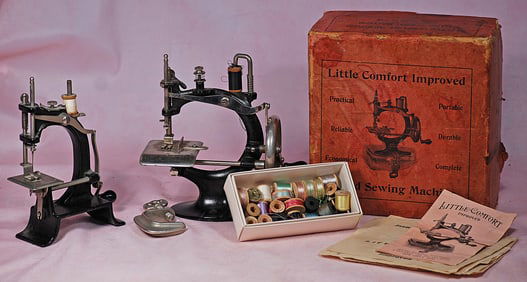 TWO TOY SEWING MACHINES, SPOOLS OF THREAD