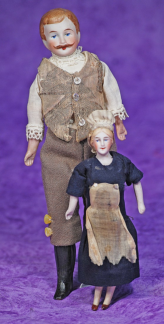 TWO GERMAN BISQUE DOLLHOUSE DOLLS.: TWO GERMAN BISQUE DOLLHOUSE DOLLS. Each is bisque shoulderhead with sculpted and painted hair, painted features, cloth body with bisque lower limbs. 5” doll with blonde hair in original maid cos