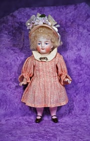 GERMAN ALL-BISQUE DOLL WITH PINK STOCKINGS.