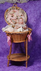 GERMAN ALL-BISQUE BABY IN WICKER LAYETTE.