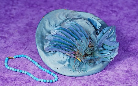 BLUE SILK DOLL BONNET AND NECKLACE. Blue silk bonnet has firmly-shaped crown accented with blue silk