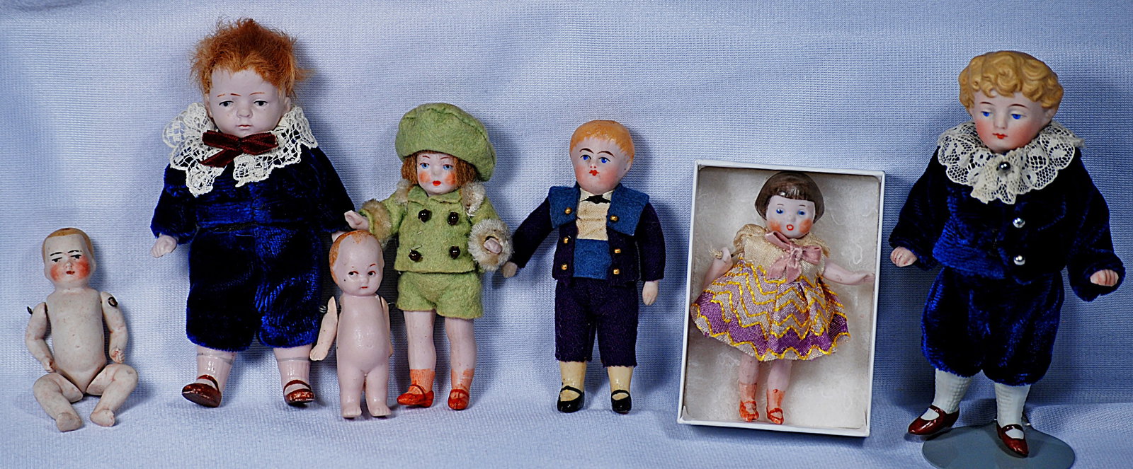 SEVEN MINIATURE GERMAN ALL-BISQUE DOLLS.: 288. SEVEN MINIATURE GERMAN ALL-BISQUE DOLLS. 2 ½” to 5”. Each is all-bisque with jointed bisque body, painted features; sculpted hair or mohair wig; three with factory original cos