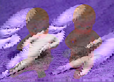 PAIR OF GERMAN ALL-BISQUE SEATED CHARACTERS BY GEBRUDER HEUBACH.