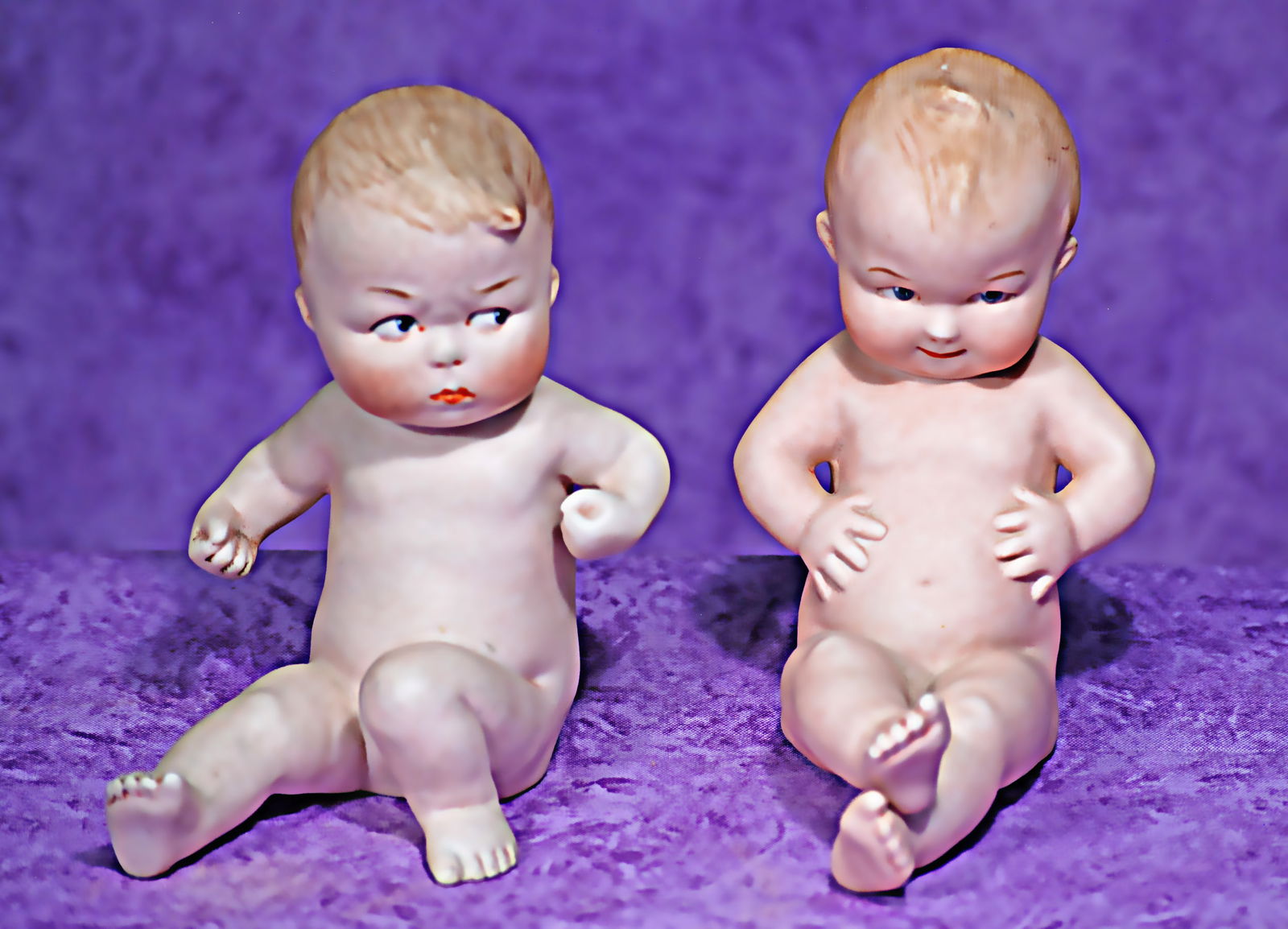 PAIR OF GERMAN ALL-BISQUE SEATED CHARACTERS BY GEBRUDER HEUBACH.: 11. PAIR OF GERMAN ALL-BISQUE SEATED CHARACTERS BY GEBRUDER HEUBACH. 5”. Each is all-bisque figure of little seated nude baby in realistic pose with sculpted and painted hair, painted features,