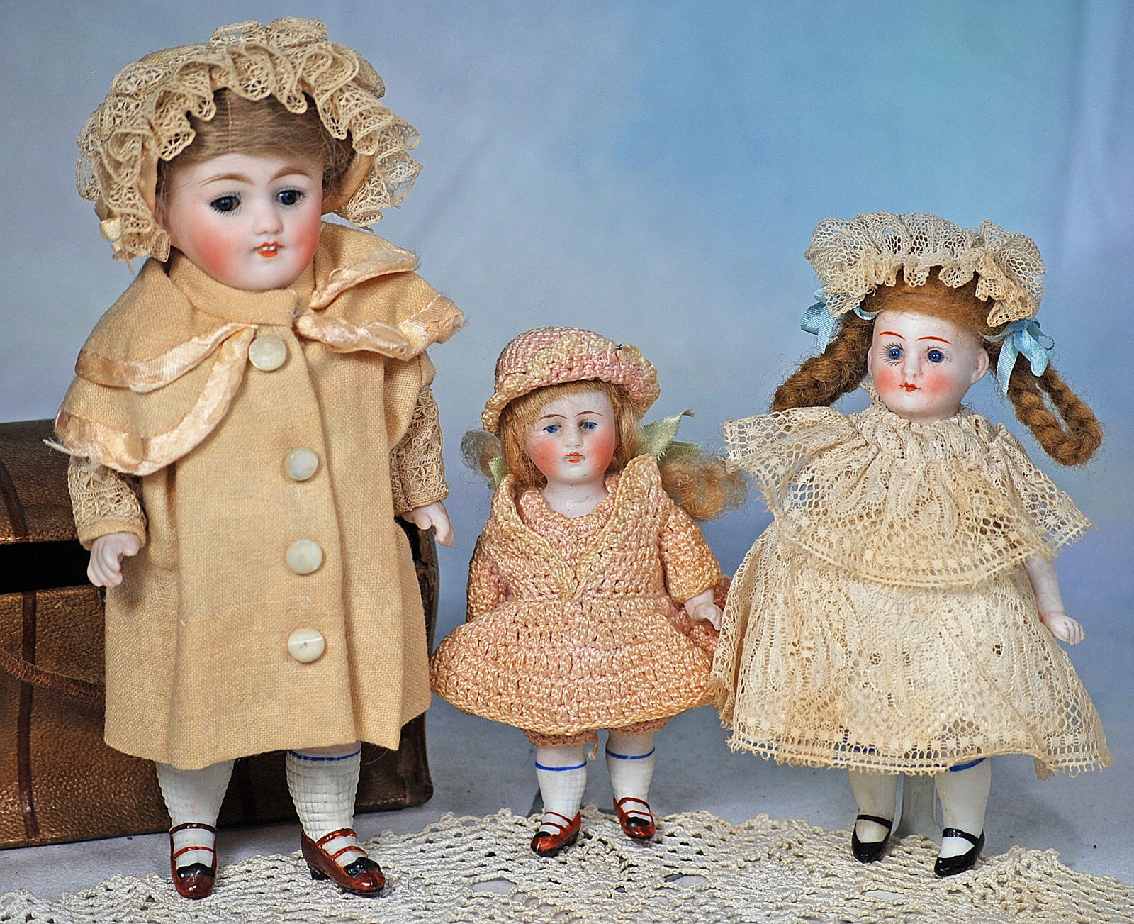 THREE GERMAN ALL-BISQUE DOLLS: 22. THREE GERMAN ALL-BISQUE DOLLS. 4” to 7”. Each is all-bisque with painted knee stockings and shoes. 4” doll has painted features, closed mouth, original wig, crocheted dress, join