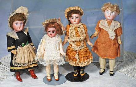 FOUR MINIATURE BISQUE DOLLS.