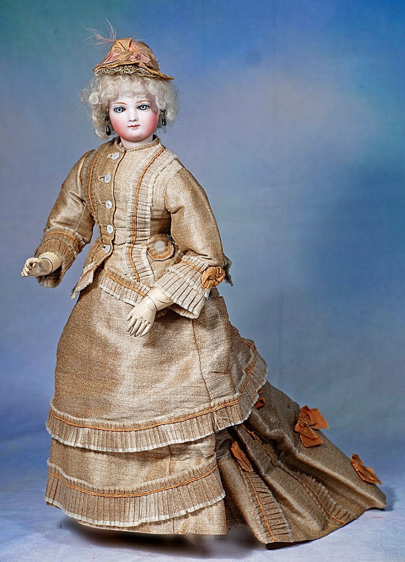 FINE FRENCH BISQUE POUPEE BY JUMEAU WOODEN ARMS: 17 ½”. Bisque swivel head on kid-edged bisque shoulderplate, blue glass paperweight eyes with spiral threading and darker blue iris rims, dark eyeliner, mauve blushed eye shadow, pain