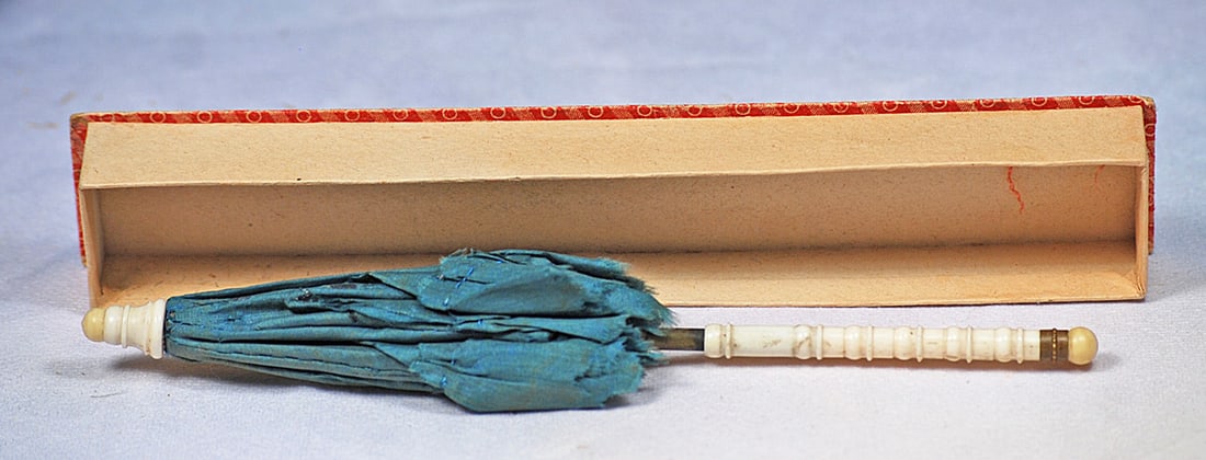 ANTIQUE DOLLS SILK PARASOL:  11”. Green silk parasol with ruffle detail, turned bone handle and tip, metal fitting, in original box without box lid.
