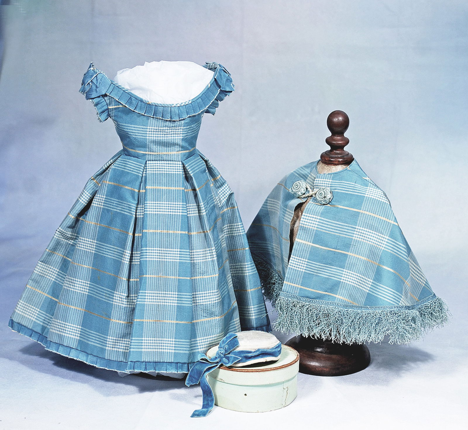 FINE AQUA SILK ENSEMBLE FOR POUPEE: ine patterned silk made up in a gown with fitted bodice having rounded low neckline and caplet sleeves of box-pleated aqua silk, box-pleated skirt, long fringed lappets at the back waist; with matchin