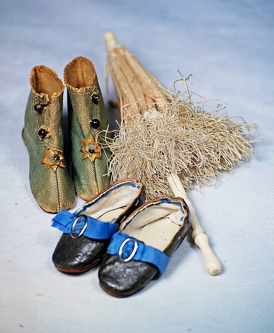ANTIQUE DOLL SHOES AND PARASOL: air of sage green leather doll boots with tiny wooden heels, side button closing, gilt decoration, 2 ¾” length, marked with J.J. trademark symbol; pair of black leather slippers with blue