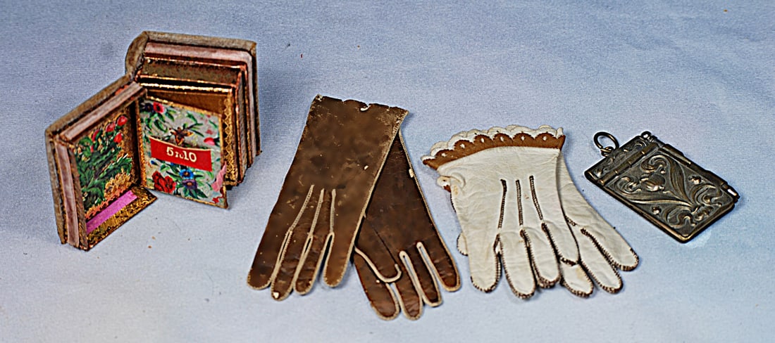 FRENCH ACCESSORY ITEMS FOR POUPEE OR BEBE: 2” folio featuring gilt backed scenic lithographs, 4” pair of brown kidskin gloves, 3 ½” pair of white kidskin gloves with scalloped edge detail, 2” x 1 ¼”