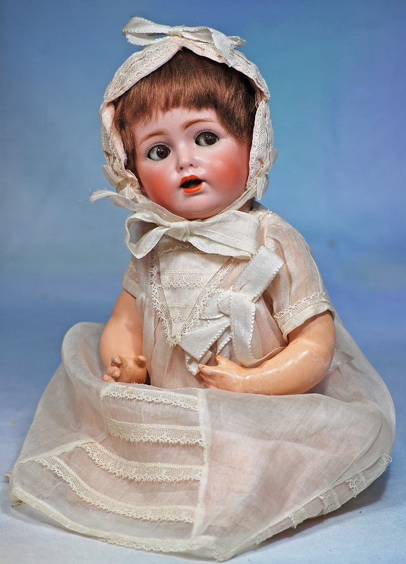 GERMAN BISQUE FLIRTY-EYED CHARACTER BABY BY KESTNER: 12”. Marks: made in Germany JDK 257. Bisque socket head, blue flirty and sleep eyes, painted lashes and applied upper lashes, feathered brows, open mouth, shaded and accented lips,
