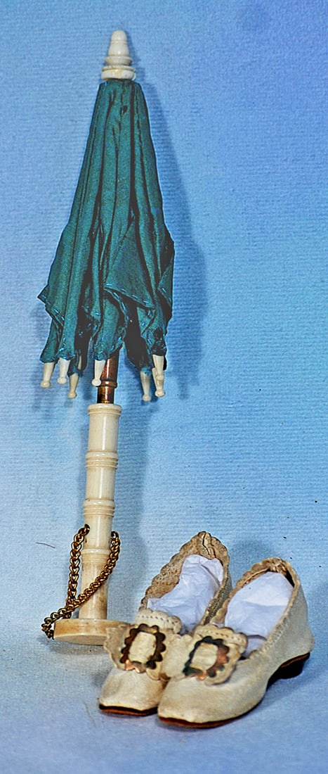 ANTIQUE SILK PARASOL AND PAIR OF WHITE LEATHER DOLL SHOES: 6 ¾” teal silk parasol with shaped bone handle and tips, metal fittings, gilt link chain; pair of soft white kidskin slippers with bows and gilt buckles, tiny wooden heels, 2” length.