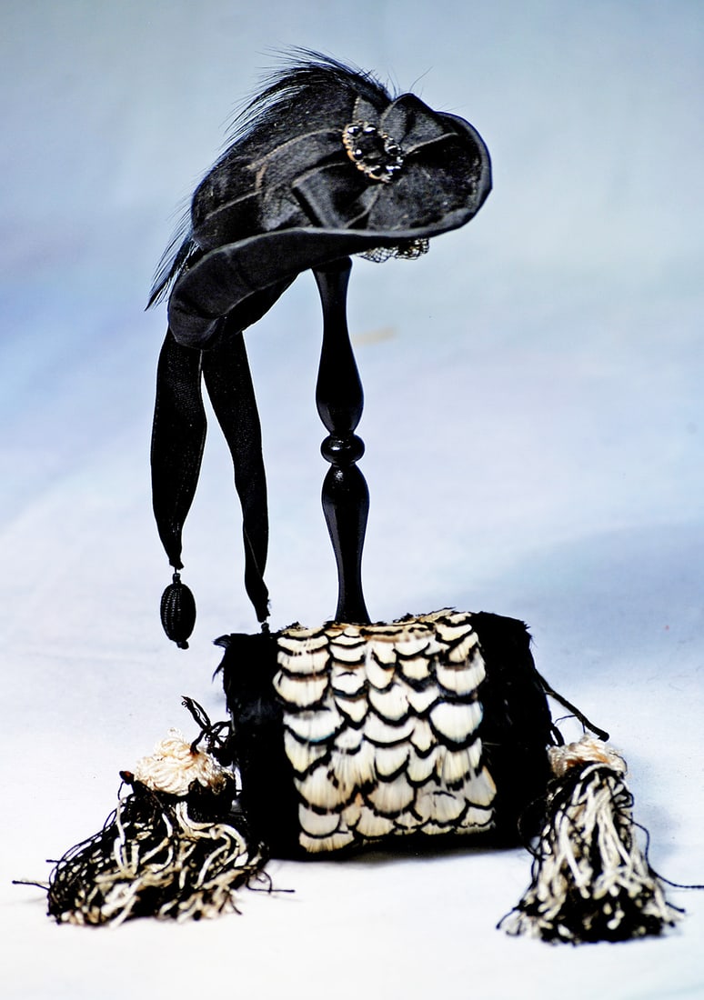 BLACK AND WHITE FEATHER MUFF AND VELVET BONNET FOR POUPEE: 3” muff constructed of black and white feathers in scalloped fashion with black and white tassels; along with a black velvet bonnet with shaped brim, silk ribbons, bow and feather, for
