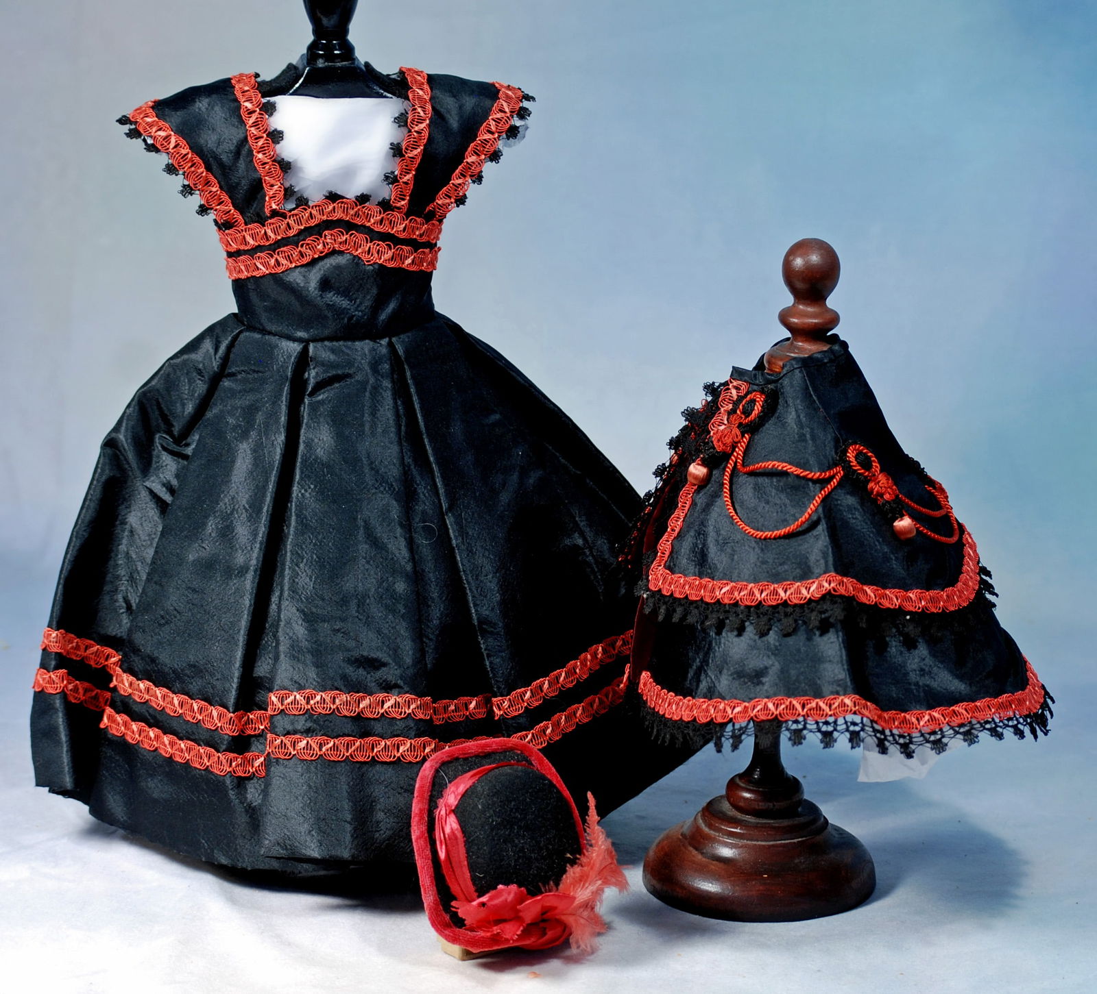BLACK SILK TAFFETA FASHION ENSEMBLE FOR POUPEE: Sized for 17”-18” poupee. Luxurious black silk taffeta gown trimmed red braid along the edge of the pointed waistband and straps, further accented with picot loops of lace