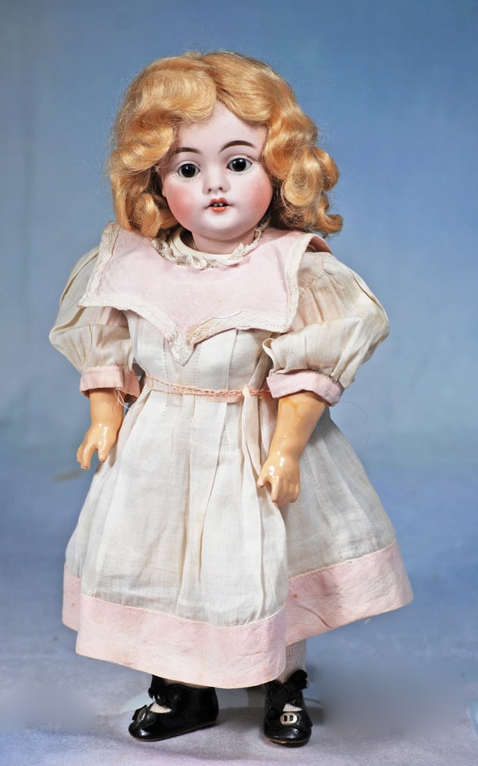 GERMAN BISQUE DOLL, MODEL 143, BY KESTNER:  11”. Marks: made in Germany 143. Bisque socket head, brown sleep eyes, painted lashes, feathered brows, open mouth, accented lips, two upper teeth, blonde mohair wig, plaster p