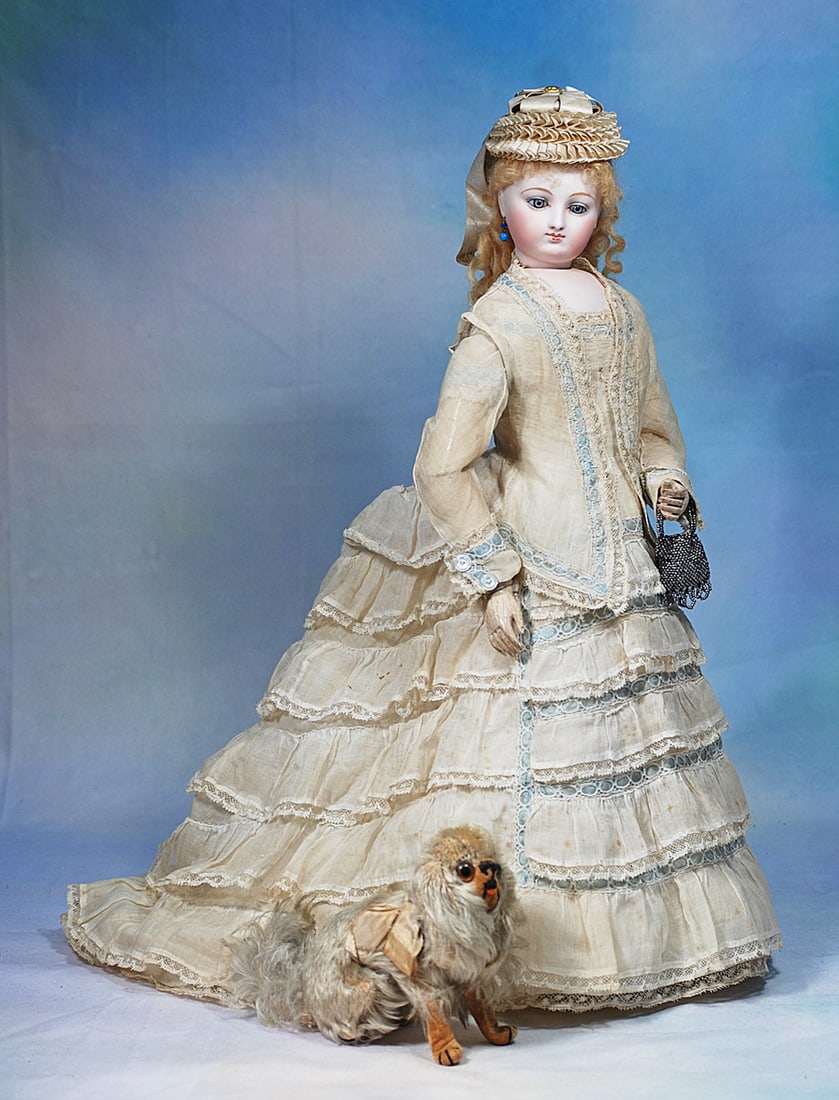 FRENCH BISQUE POUPEE WITH ARTICULATED WOODEN BODY AS SEEN IN “THE PARIS COLLECTION” BY: 18”. Marks: 4. Bisque swivel head on bisque shoulderplate, blue paperweight eyes, painted lashes, defined eyelids with dark eyeliner, feathered brows, pierced ears, full cheeks, closed mou