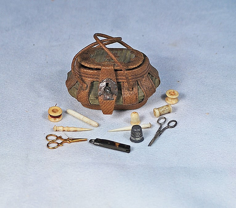 TINY FRENCH NECESSAIRE FOR POUPEES: 2” x 1 ½”. Bombe-shaped firm-sided sewing necessaire with twin handles, hinged cover and containing tiny scissors, knife, thimble threads and bode sewing tools.