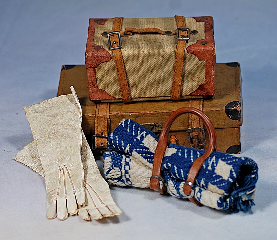 ANTIQUE TRAVEL ACCESSORIES FOR DOLLS: 5 ½” and 3 ¾” firm-sided travel cases, 4 ¼” blue and white woven wool blanket wrap with leather carrying straps, pair 5” L. soft white kidskin gloves.