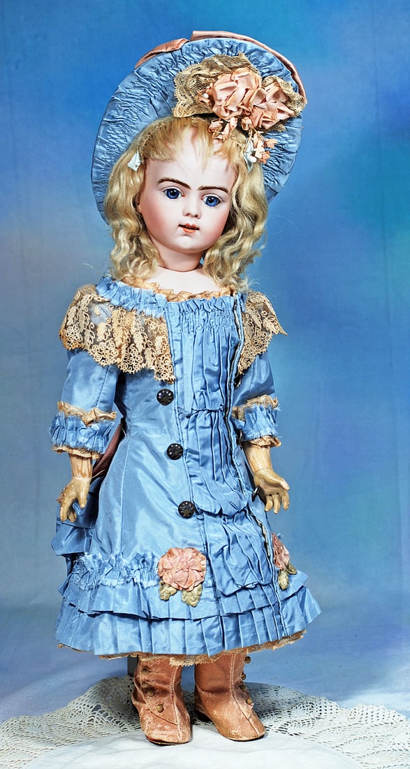 FRENCH BISQUE BEBE BRU JNE R BY WITH EARLY BODY STYLE: 21”. Marks: Bru Jne 4 9 (head); Bru 7 (shoulderplate). Bisque swivel head on bisque shoulderplate, blue paperweight eyes, painted lashes, dark eyeliner, feathered brows, pierced ears, open