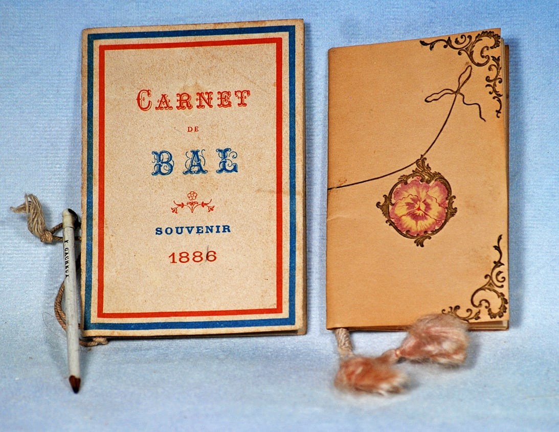 CARNE DE BAL 1888 DANCE CARD AND 1911 CALENDAR BOOKLET: 3 ¾” x 2 ¼” cardboard souvenir of an elegant ball, with dances and partners listed on the inside pages along with tiny writing pencil stamped F. Gauheux, cord and silk tassel; 3