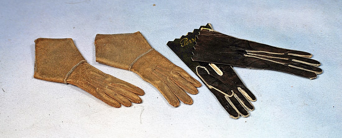 TWO PAIR OF ANTIQUE DOLL GLOVES: Soft kidskin gloves with stitching detail; 4” pair in camel tan color with unique styling and 4” pair of dark brown gloves with cream stitching and marked “Paris” in gilt