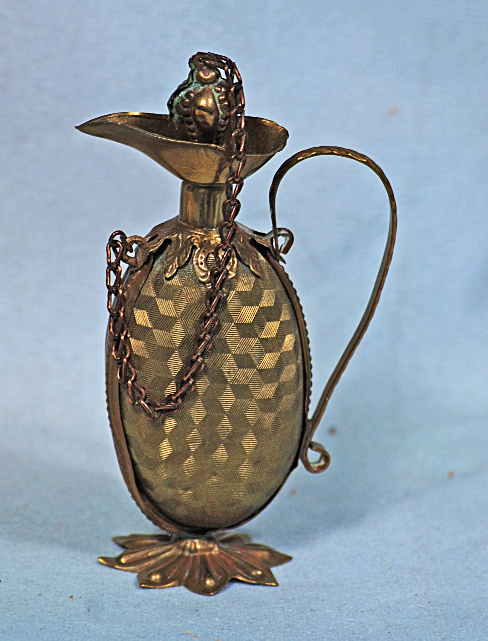 FRENCH MINIATURE EMBOSSED METAL PERFUME FLASK: 3 ½”. Urn-shaped gilt perfume holder with gracefully shaped handle and base, gilt metal link chain attached to the stopper.
