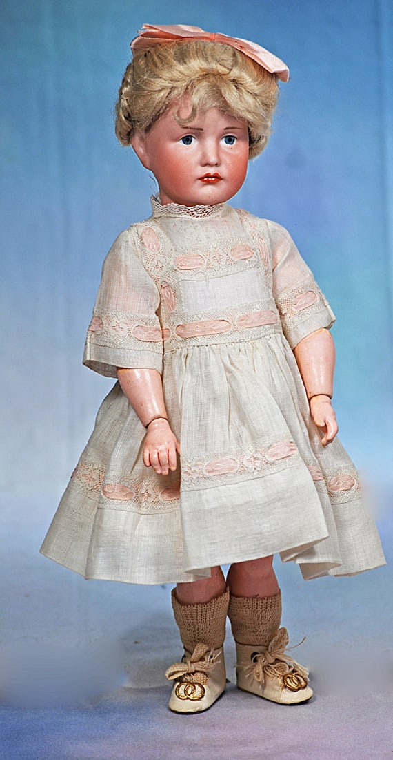GERMAN BISQUE ART CHARACTER. 114. BY KAMMER AND REINHARDT: 12”. Marks: K * R 114. Bisque socket head, painted features, blue eyes, upper eyeliner, tapered brows, closed mouth, accented and shaded lips in pouty expression, antique blonde moha