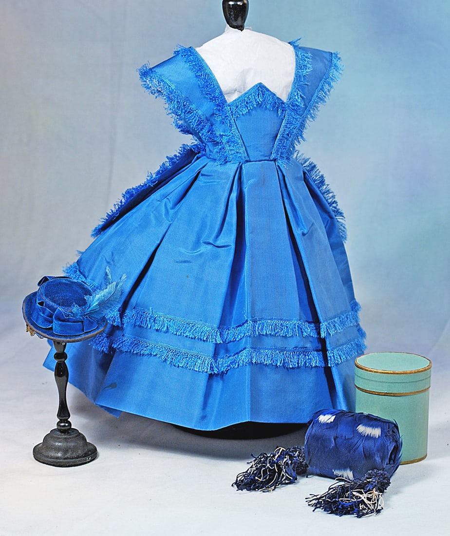 GORGEOUS BLUE SILK ENSEMBLE FOR POUPEE: Features a fine cerulean blue silk taffeta gown with bretelles set over the pointed high waistband and extending over the back falling into long lappets which are trimmed all around with matching
