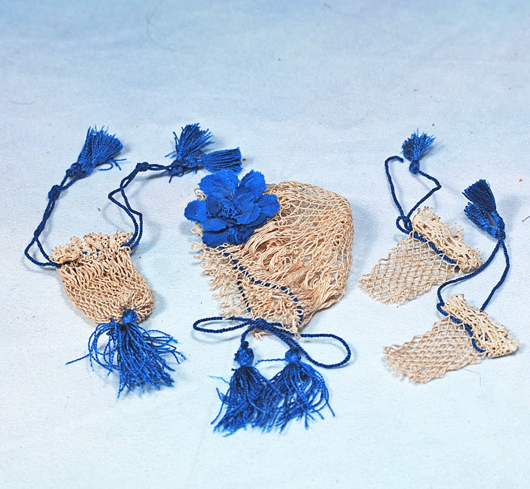 SET OF HAND-NETTED ACCESSORIES FOR POUPEE: Includes half mitts, purse, and bonnet all garnished with blue ribbons, cords and blue silk tassels,