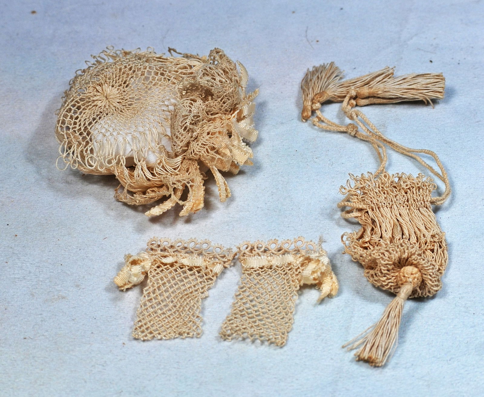 ACCESSORIES FOR POUPEE: Comprising hand-netted cap trimmed with loops of ribbon at the front, a purse with silk tassels, and pair of mitts.