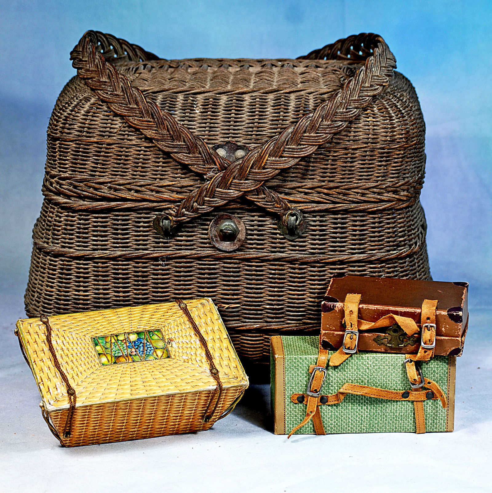 ANTIQUE FRENCH WICKER BASKET AND TRAVEL ACCESSORIES: 6” x 2” faux wicker trunk with hinged lid with French shop label of “L. Dreamard Fils, Carentas Mache”, plus two small paper-covered trunks with leather straps, and a 6” x