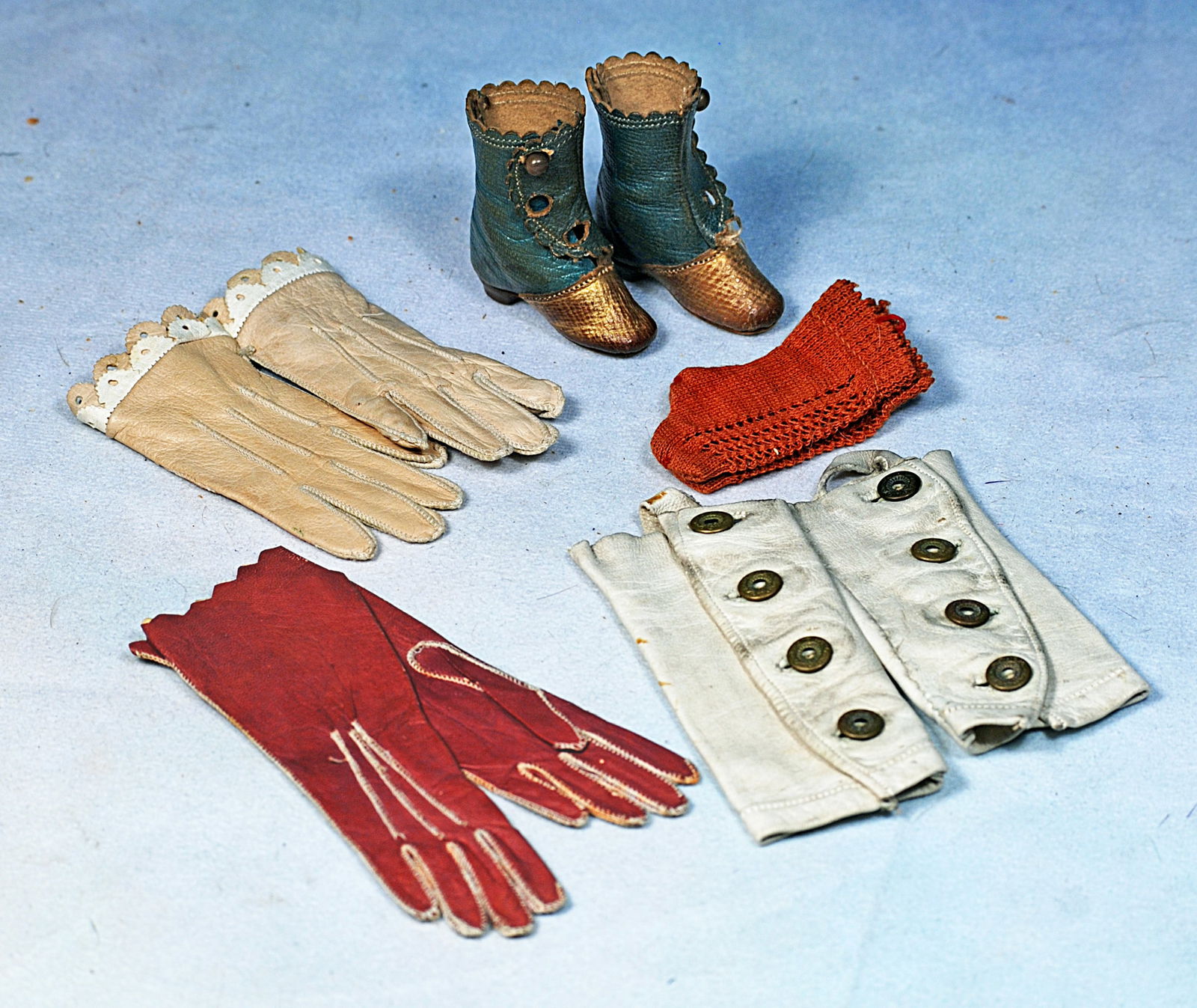 ANTIQUE ACCESSORIES FOR POUPEE OR BEBE: Includes: 4” pair of light maroon leather gloves with cream stitching detail, 3” pair of light tan leather gloves with double row of scalloped detail and buttons in back; 3 ½” p