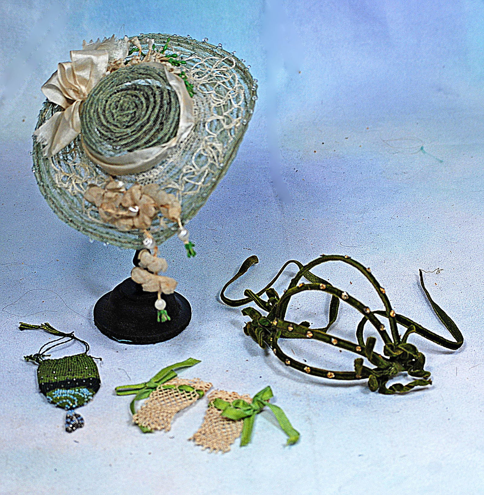 ACCESSORIES FOR POUPEE: Includes a green crinoline bonnet with wide brim and tiny crystal beads silk ribbons and flowers, streamers and tiny green droplets; pair of hand-knitted green mitts, and a hat band covered in dark