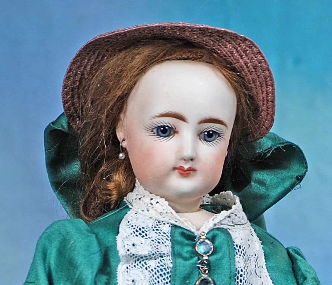 FRENCH BISQUE POUPEE BY GAULTHIER: 17”. Marks: 4. Bisque swivel head on bisque shoulderplate, blue paperweight eyes, painted lashes, eyeliner, feathered brows, pierced ears, closed mouth, accented lips, brown syntheti