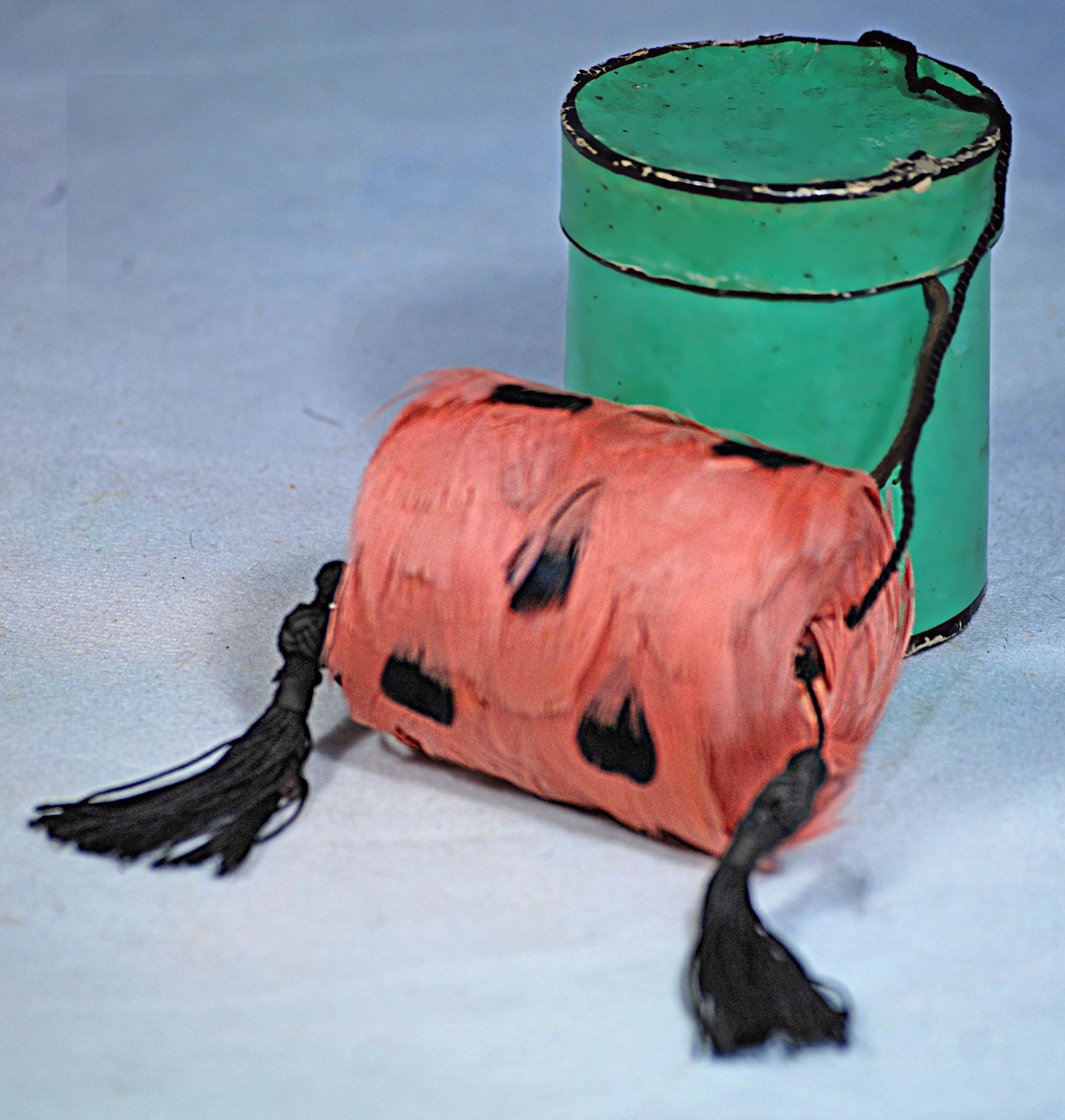 PINK FEATHER MUFF: 248. PINK FEATHER .2 ½” Pink feather muff spotted with black enhanced by black silk tassels, in cylinder cardboard box.