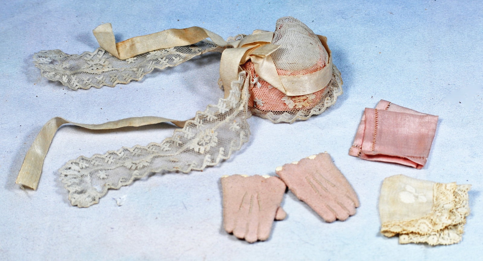 PAIR OF PINK GLOVES,BONNET AND HANDKERCHIEFS.: 249. PAIR OF PINK GLOVES,BONNET AND HANDKERCHIEFS. 1 3/4:” Soft pink leather wrist gloves with buttons at back; two small handkerchiefs, white organdy bonnet with pink band covered by white