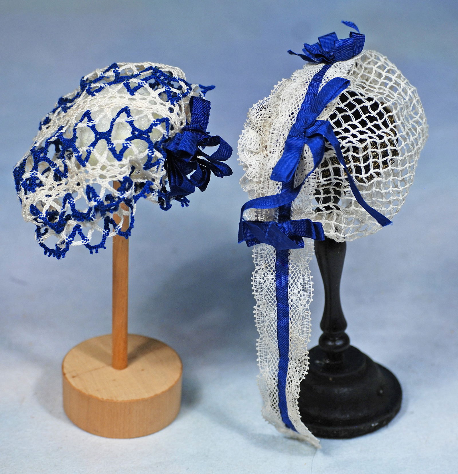 TWO HAND-TIED BONNETS: 251. TWO HAND-TIED BONNETS. Includes bonnet made up in hand-ties net trimmed with Val lace and royal blue ribbon and bows with long pendants at each side; plus hand-tied royal blue and white cap