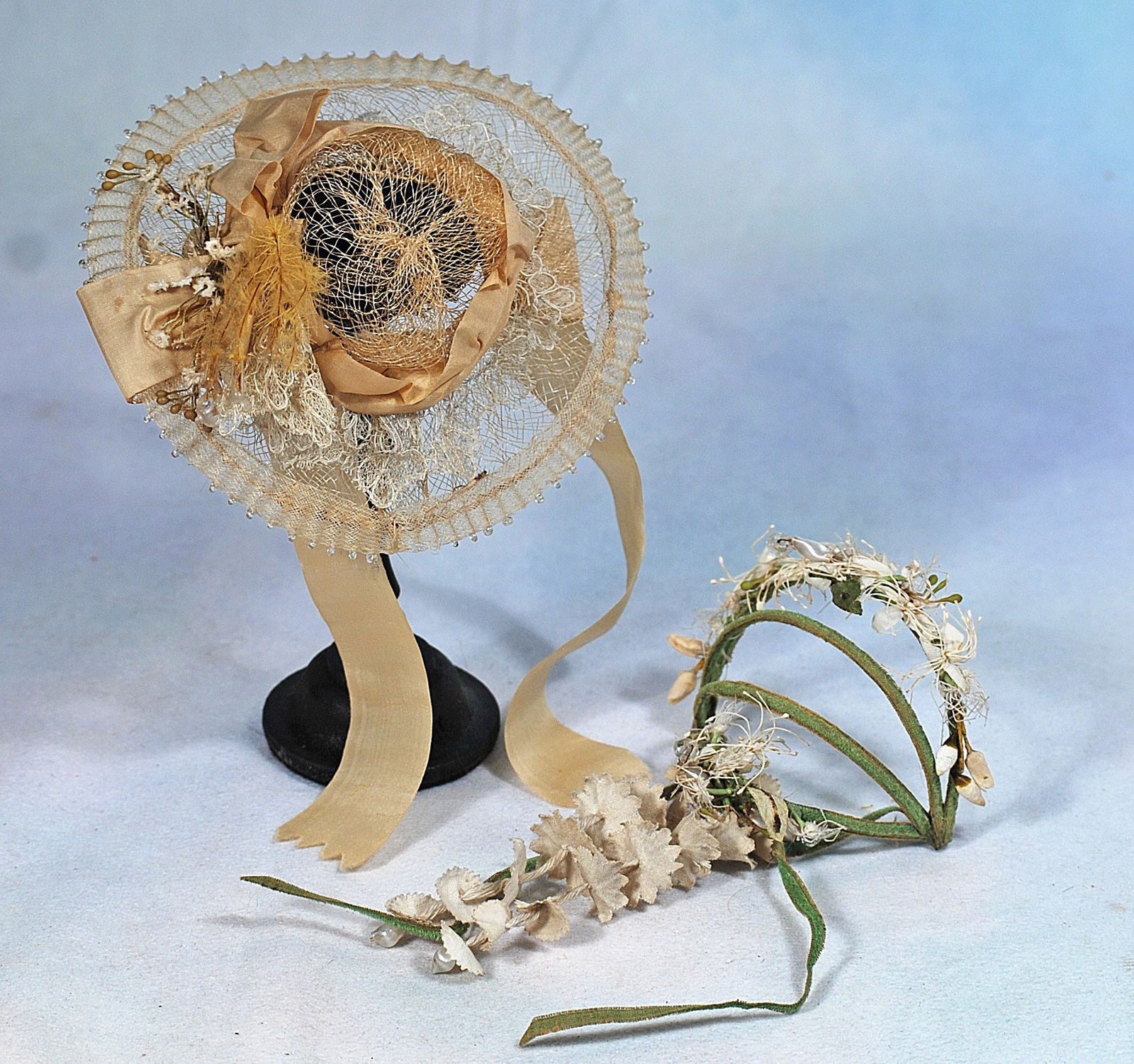DOLL BONNET AND CORONET.: 266. DOLL BONNET AND CORONET. An airy crinoline bonnet decorated with lace and silk ribbons and a puff of feathers enhanced by little pendant balls, silk ribbon ties; plus a coronet comprised of three