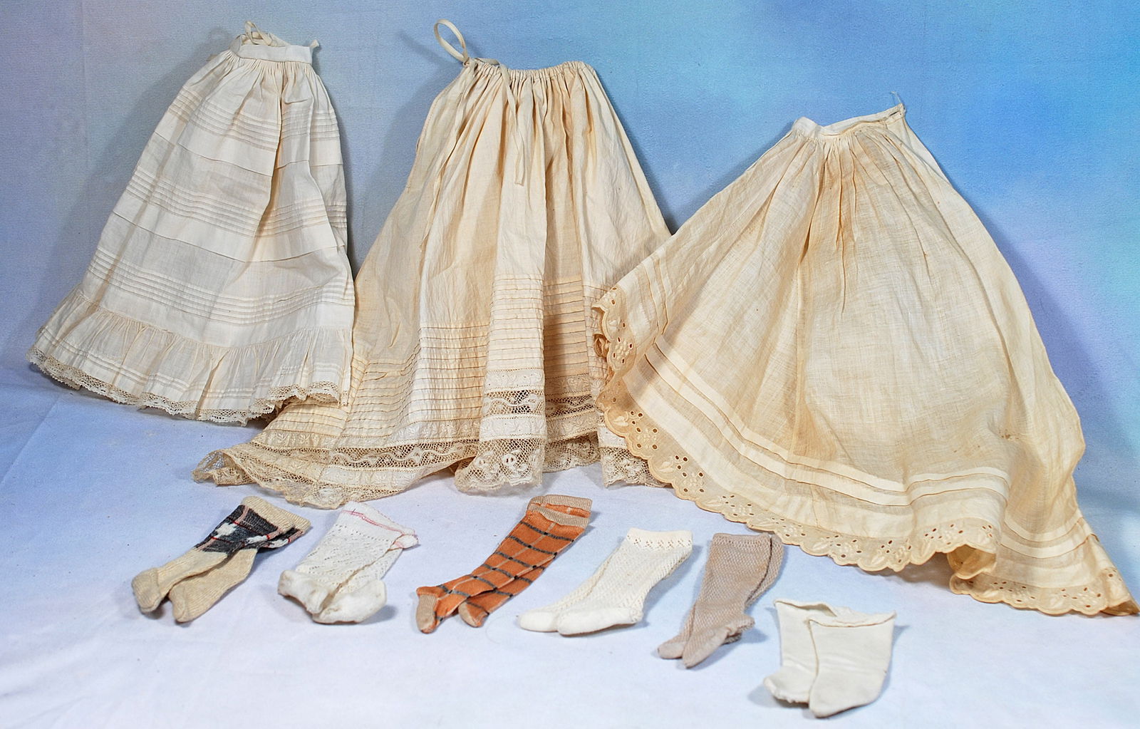SIX PAIRS OF ANTIQUE DOLL STOCKINGS AND THREE PETTICOAT (1 of 1)