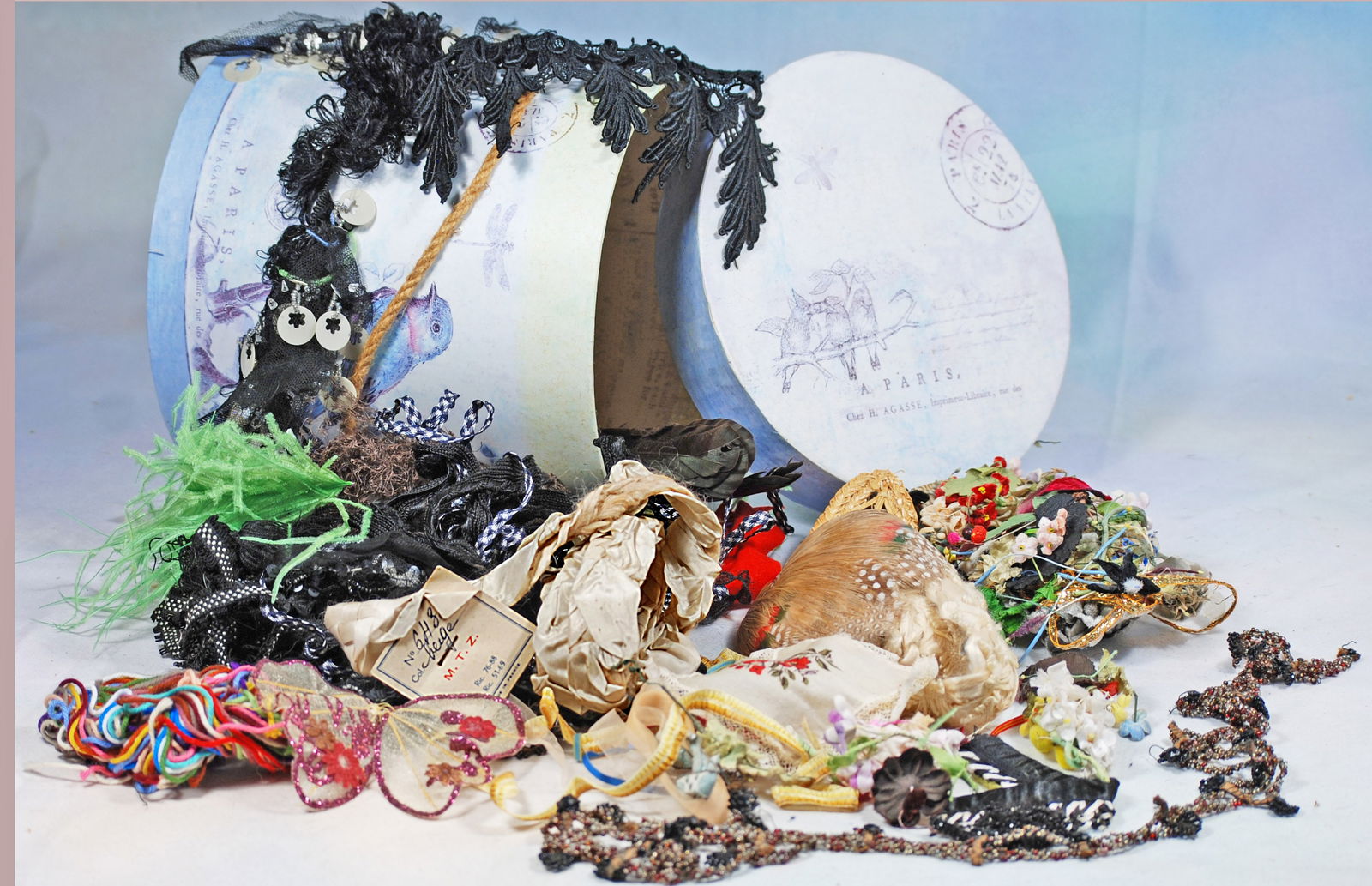 fFRENCH HAT BOX FILLED WITH ANTQUE RIBBONS AND TRIMS: 293. FRENCH HAT BOX BILLED WITH ANTIQUE RIBBONS AND TRIMS TOR DOLL COSTUMING. large hat box with French labels filled with assorted binding.fringes, ribbons, flowers, crystal beading and more.