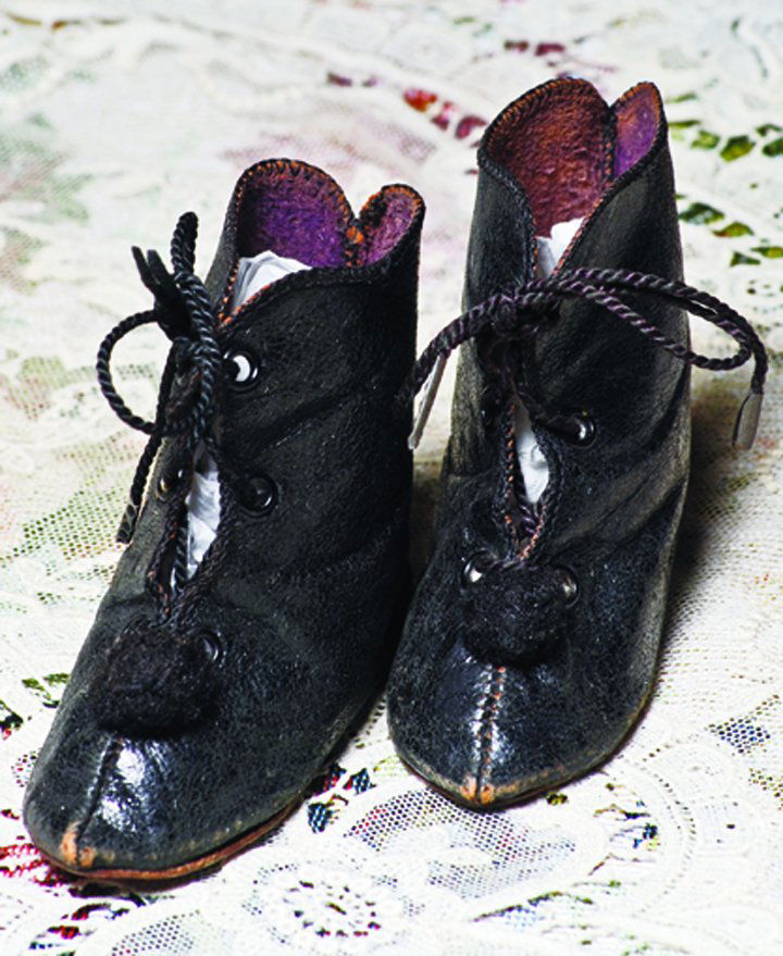 PAIR OF FRENCH LEATHER DOLL BOOTS. Marks: Depose /: PAIR OF FRENCH LEATHER DOLL BOOTS. Marks: Depose / figure of lady. 3 ¼”. Black leather boots with pointed toes, front lace closing, black pom poms, overcast edges, leather soles. Commentary: Antiqu