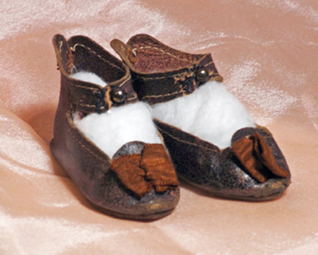 BEBE JUMEAU FACTORY DOLL SHOES. Marks: 7, bee symbol: BEBE JUMEAU FACTORY DOLL SHOES. Marks: 7, bee symbol Depose Paris. 2 ½”. Dark leather shoes with stitched edges, ankle-strap button closing, brown silk bows, embossed leather soles. Commentary: Goo